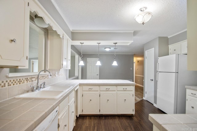 kitchen featuring a sink, white appliances, tile counters, a peninsula, and dark wood-type flooring