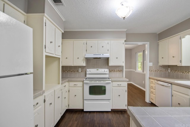kitchen featuring white appliances, tile countertops, under cabinet range hood, and dark wood-style floors