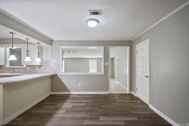 kitchen featuring a textured ceiling, visible vents, dark wood-style floors, and tasteful backsplash