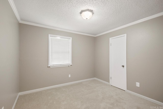 carpeted empty room with a textured ceiling, ornamental molding, and baseboards