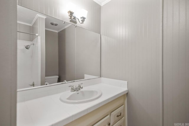 full bathroom with crown molding, toilet, vanity, and a shower
