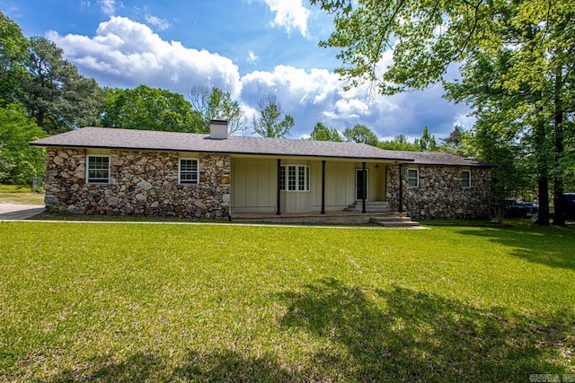 ranch-style home with a chimney, a front lawn, board and batten siding, and stone siding