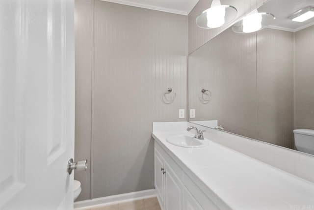 bathroom with vanity, ornamental molding, toilet, and tile patterned flooring