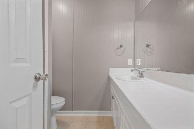 bathroom featuring toilet, tile patterned floors, baseboards, and vanity