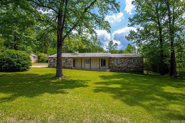 single story home featuring a chimney, a front lawn, driveway, and stone siding