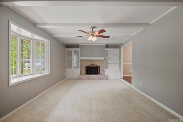 unfurnished living room featuring beamed ceiling, a fireplace with raised hearth, and baseboards