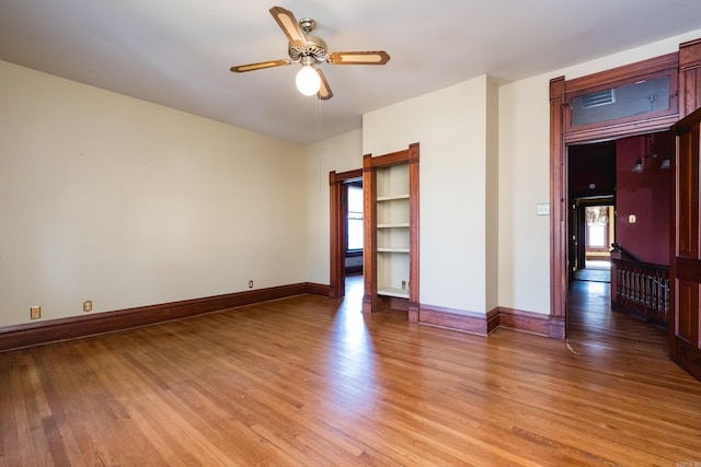unfurnished room featuring a ceiling fan, a wealth of natural light, and light wood-style flooring