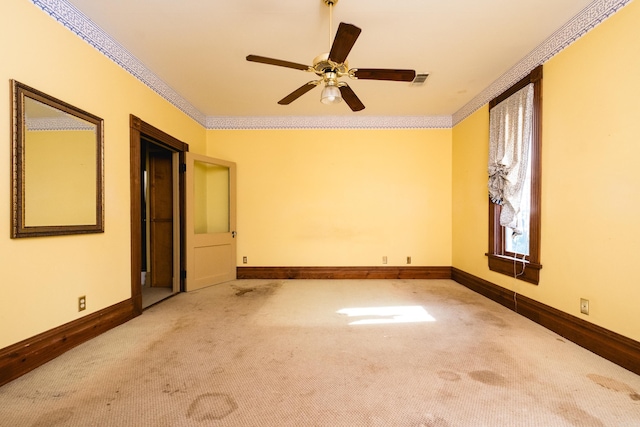 empty room with baseboards, carpet, and crown molding