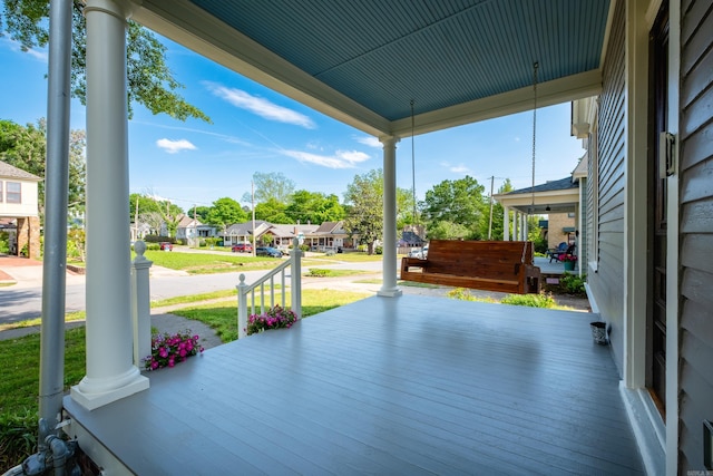 wooden terrace featuring a residential view and covered porch