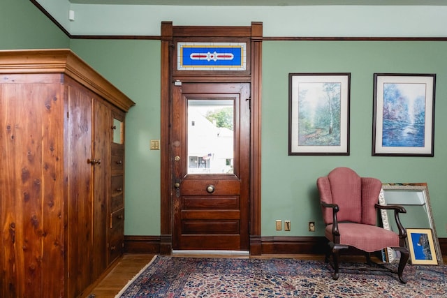 interior space featuring baseboards, ornamental molding, and wood finished floors