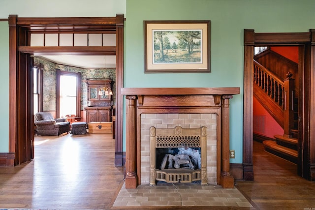 living area with visible vents, stairs, wood finished floors, and a fireplace