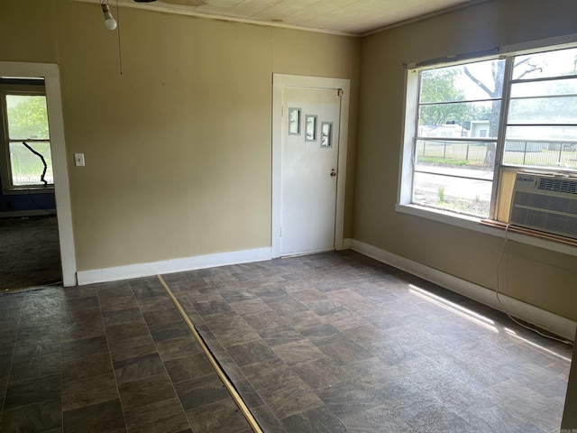 spare room with baseboards and cooling unit