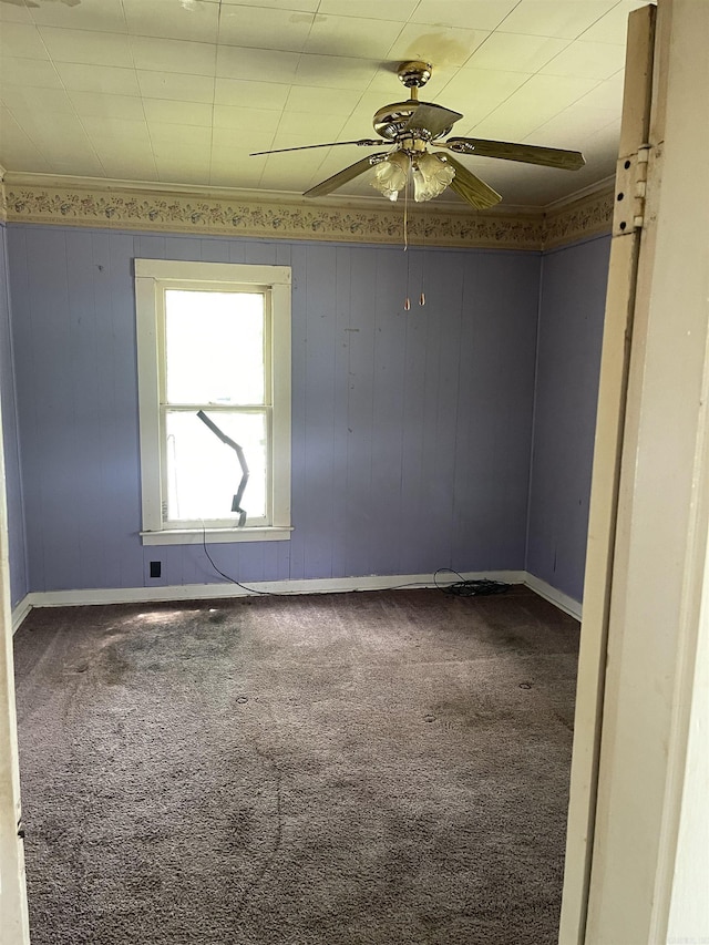spare room featuring baseboards, a ceiling fan, crown molding, and carpet flooring