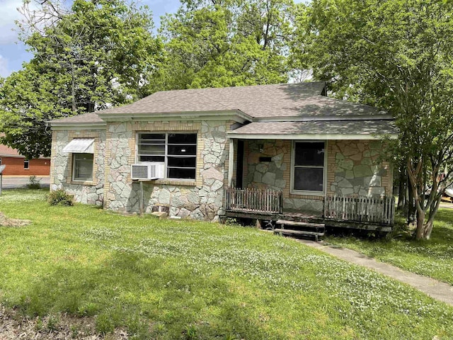 view of front of property featuring covered porch, a shingled roof, and stone siding