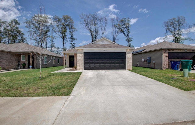 single story home with brick siding, a front lawn, and concrete driveway