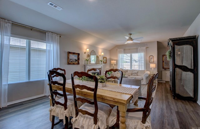 dining room with ceiling fan, visible vents, wood finished floors, baseboards, and lofted ceiling