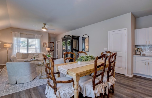 dining area featuring ceiling fan, dark wood finished floors, baseboards, and lofted ceiling
