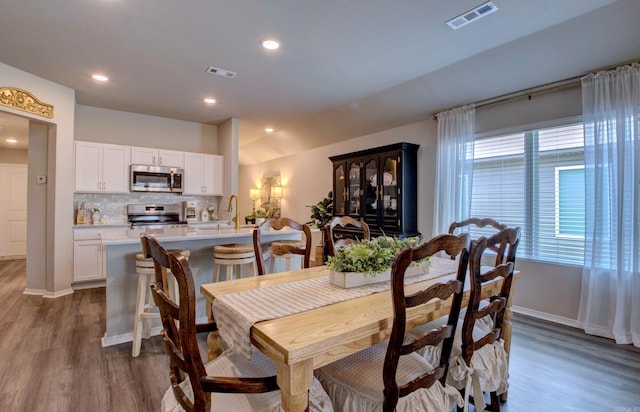 dining room featuring visible vents, recessed lighting, baseboards, and wood finished floors