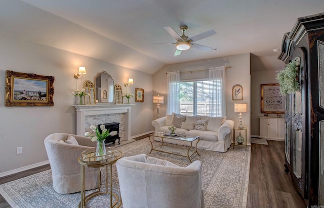 living area featuring a brick fireplace, ceiling fan, dark wood-style floors, and baseboards