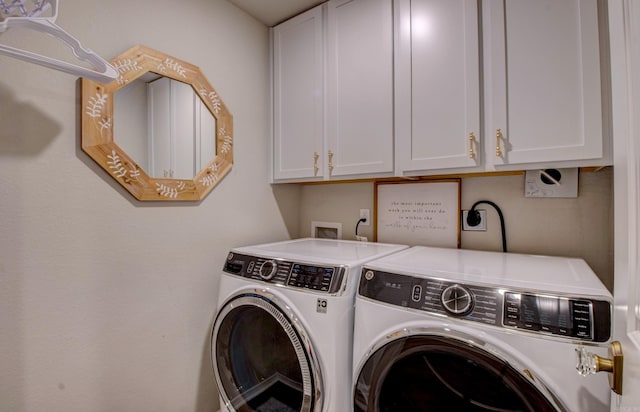 washroom featuring washing machine and dryer and cabinet space