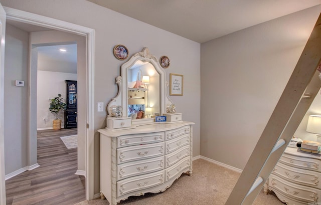 corridor with baseboards and light wood-style flooring