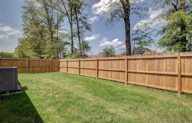 view of yard with central AC unit and a fenced backyard