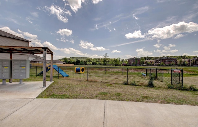 view of yard with fence and mail area