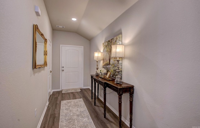 entryway with baseboards, vaulted ceiling, dark wood-style flooring, and visible vents