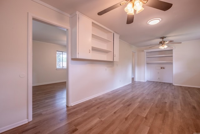 interior space featuring crown molding, a ceiling fan, and light wood-type flooring