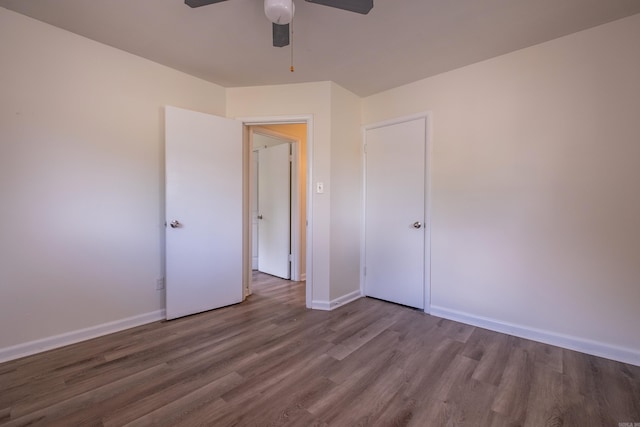 unfurnished bedroom with a ceiling fan, baseboards, and wood finished floors