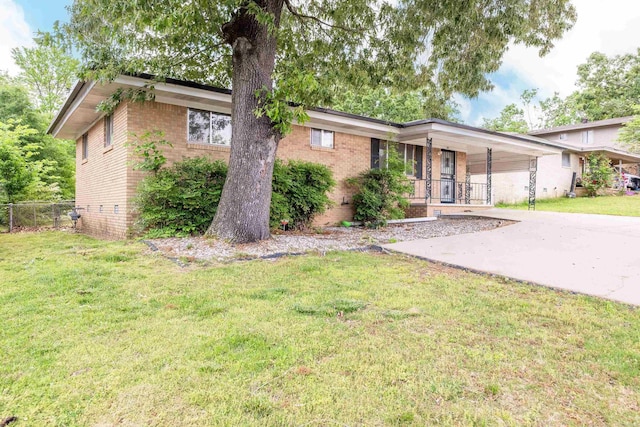 ranch-style home with brick siding, fence, covered porch, and a front yard