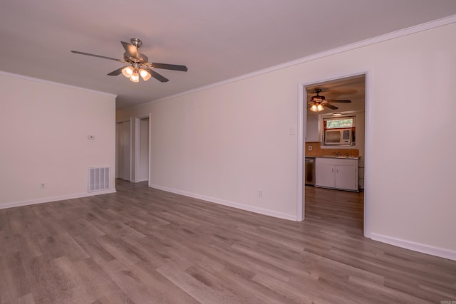 unfurnished living room with ornamental molding, a ceiling fan, wood finished floors, and visible vents