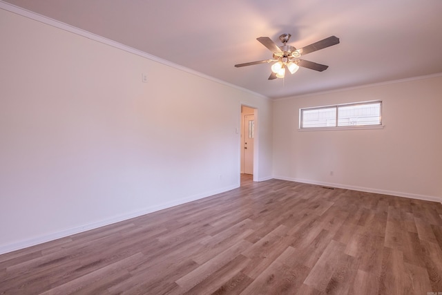 unfurnished room with crown molding, baseboards, ceiling fan, and wood finished floors
