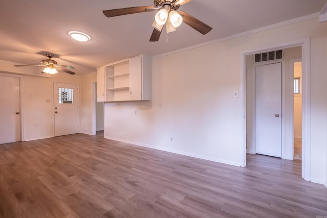 unfurnished living room with ceiling fan, ornamental molding, wood finished floors, and visible vents