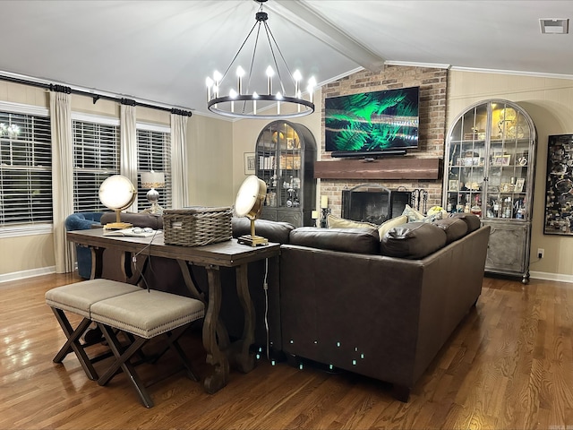 living room with a notable chandelier, visible vents, lofted ceiling with beams, and wood finished floors
