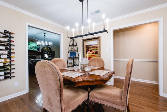 dining room featuring visible vents, ornamental molding, baseboards, dark wood-style floors, and a notable chandelier