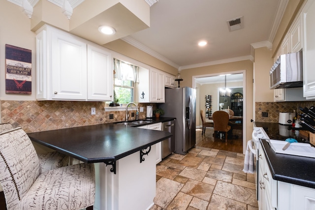 kitchen with visible vents, crown molding, dark countertops, appliances with stainless steel finishes, and a sink