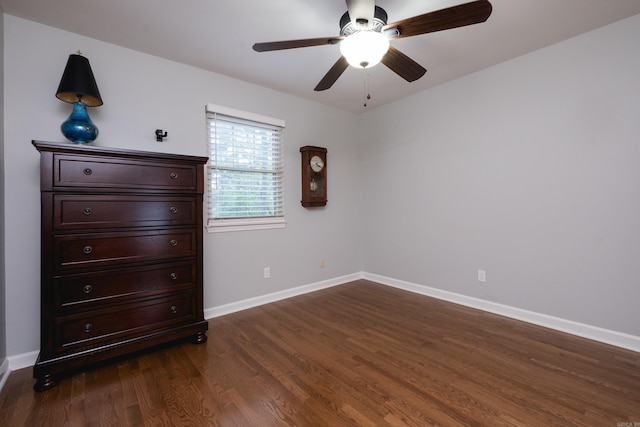 unfurnished bedroom with dark wood-style flooring, baseboards, and ceiling fan