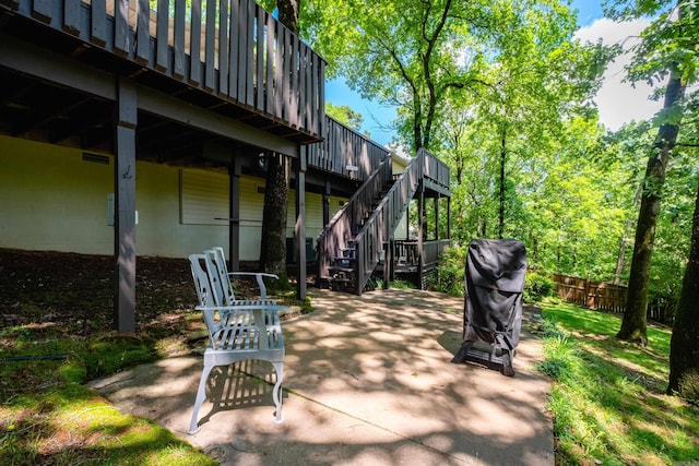 view of patio featuring stairs, fence, and a grill