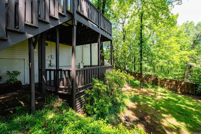 view of side of home featuring a deck and fence