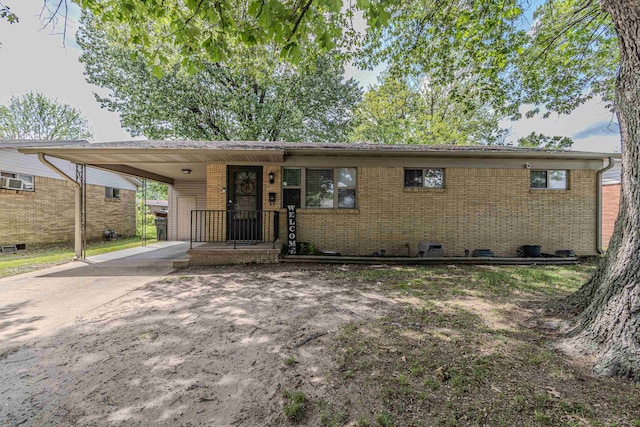 ranch-style house featuring brick siding, crawl space, driveway, and an attached carport