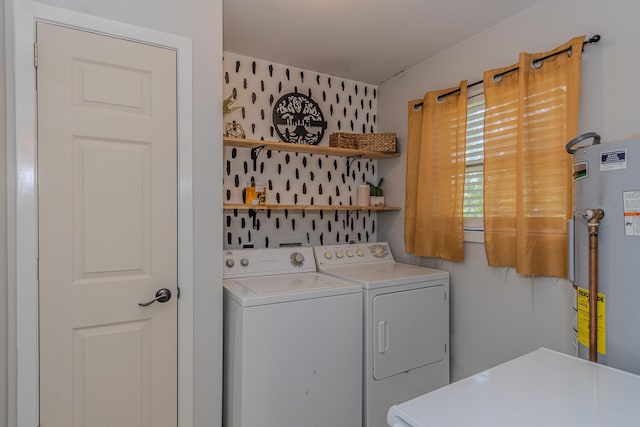 washroom with water heater, separate washer and dryer, and laundry area