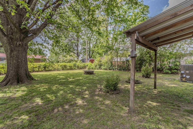 view of yard with central AC unit and an outdoor fire pit