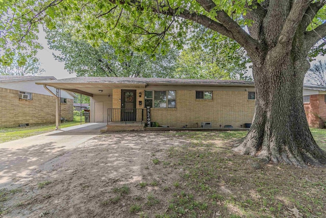 ranch-style home featuring brick siding, driveway, and an attached carport