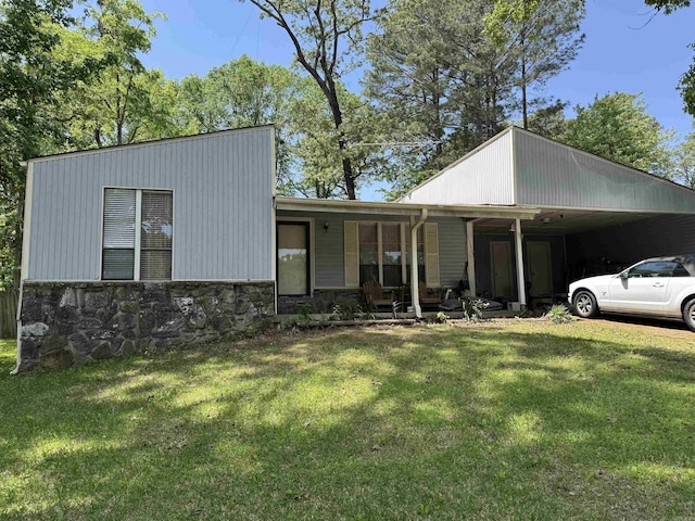 view of front facade with a carport, stone siding, and a front yard
