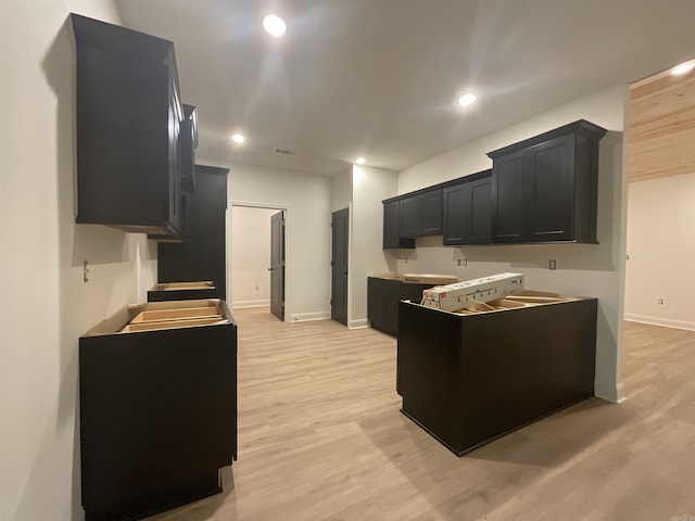 kitchen with dark cabinets, light wood-style flooring, recessed lighting, baseboards, and visible vents