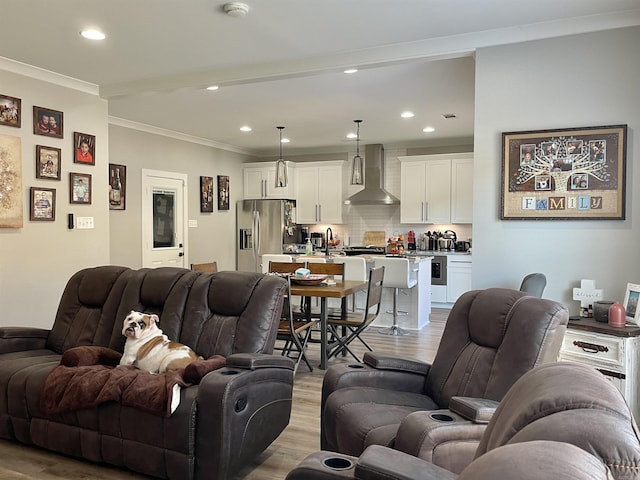 living room featuring ornamental molding, light wood finished floors, and recessed lighting
