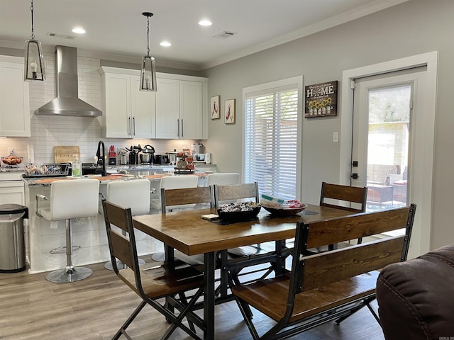 dining area with light wood-type flooring, ornamental molding, visible vents, and recessed lighting