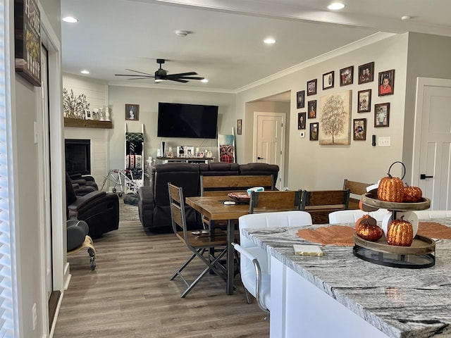 dining space featuring crown molding, a ceiling fan, wood finished floors, and recessed lighting