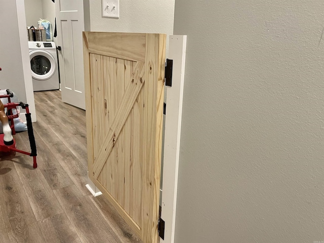 details featuring washer / dryer, a textured wall, and wood finished floors